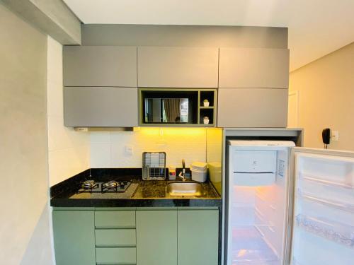 a small kitchen with a sink and a refrigerator at Ocean Porto Flats in Porto De Galinhas