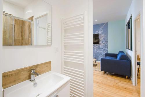 La salle de bains est pourvue d'un lavabo et d'un canapé bleu. dans l'établissement Spacious T2 Near the Halles and the Harbour, à Toulon