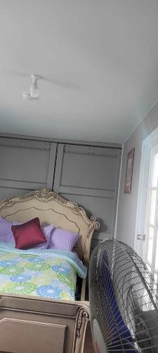 1 dormitorio con 1 cama con almohadas moradas y moradas en AJ Guesthouse en Folaha