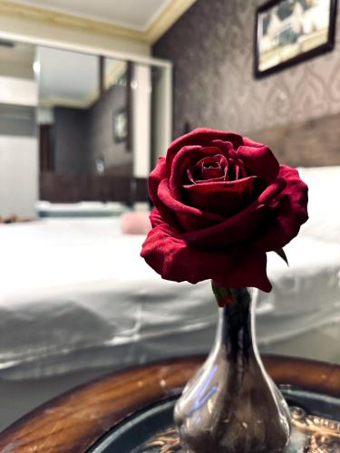 a red rose in a silver vase on a table at Balcony Hotel in Amman