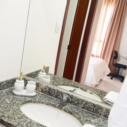 a bathroom counter with a sink and a mirror at Apartamento Recanto Azul - Vista mar in Salvador