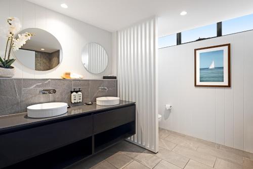 a bathroom with two sinks and a mirror at The Sebel Brisbane Margate Beach in Redcliffe