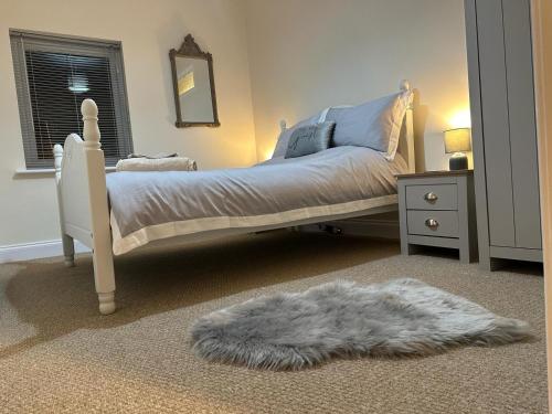 a bedroom with a white bed and a white rug at City Of Chester Award Winning Cottage -Pixie Terrace Chester in Chester