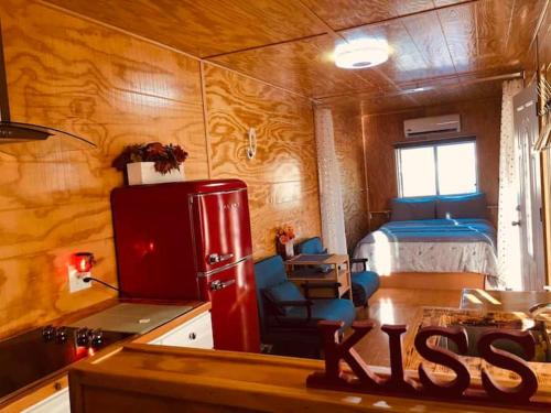 a room with a kitchen and a bedroom with a bed at Sun Tiny House A Pahrump in Pahrump