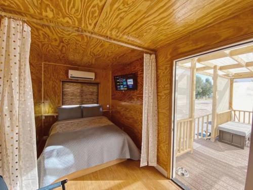 a bedroom in a house with a bed and a balcony at Sun Tiny House A Pahrump in Pahrump