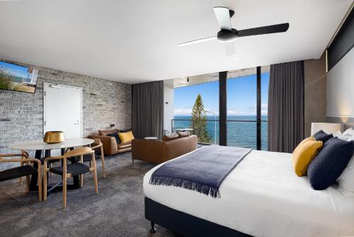 a bedroom with a large bed and a living room at The Sebel Brisbane Margate Beach in Redcliffe