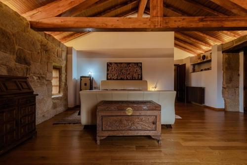 Habitación grande con cama y mesa de madera. en Habitación deluxe con chimenea y baño en casa de campo. Piscina y jardín. en Amoeiro