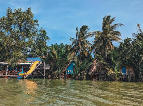 a view of a river with houses and a slide at Yellow Sun Kampot in Kampot