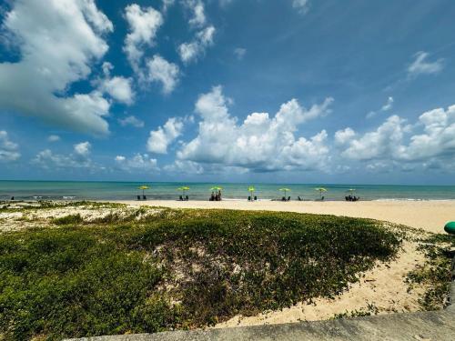 una spiaggia con ombrelloni e persone sulla spiaggia di Lar do Viajante: Apartamento 2 quartos a 300m da praia em Manaíra a João Pessoa