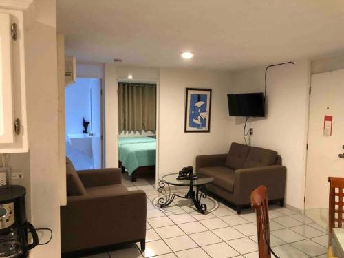 a living room with a couch and a bed at 302 Excelente apto muy Cerca de Playa in Mazatlán