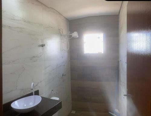 een witte badkamer met een wastafel en een douche bij Residencial linda vista casa azul in Mateus Leme