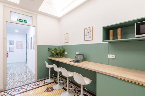 a waiting room with a counter and stools at Pensión Alicante by Moontels in Valencia