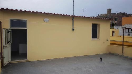 un edificio giallo con una porta e un gatto in piedi accanto ad esso di Appartamento Ruffano a Ruffano
