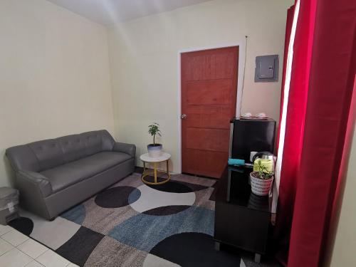 uma sala de estar com um sofá e uma porta em Air-conditioned Home em Dávao