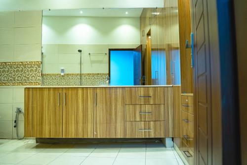 a bathroom with wooden cabinets and a large mirror at COMFORT HOME in Gujrāt