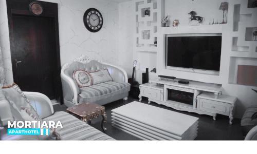 uma sala de estar com um sofá e uma televisão em A lovely luxury three bedroom house in a serene environment em Pakuro