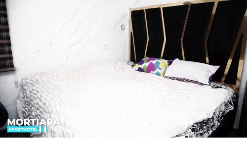 uma cama branca com duas almofadas em cima em A lovely luxury three bedroom house in a serene environment em Pakuro
