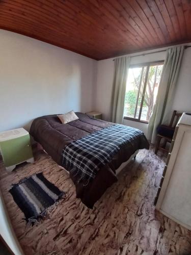 um quarto com uma cama e uma grande janela em CASA ANTONIA em Embalse