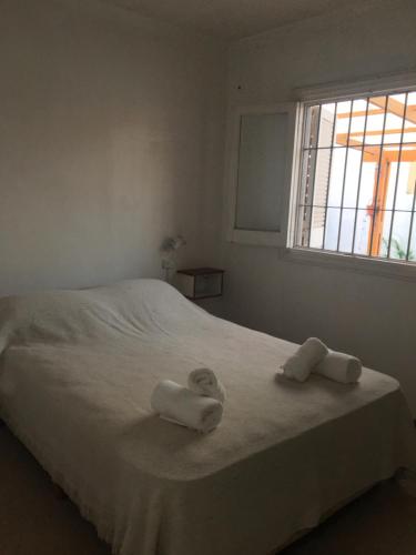 1 Schlafzimmer mit 2 Handtüchern auf einem Bett mit Fenster in der Unterkunft Silvestre in Mar del Plata