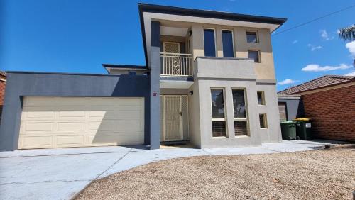 a house with two garage doors in front of it at St Albans house - Spacious and modern home in St Albans