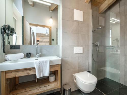 a bathroom with a sink and a toilet and a shower at Tauernlodge Liz in Mühlbach am Hochkönig