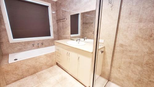 een badkamer met een wastafel en een douche bij St Albans house - Spacious and modern home in St Albans