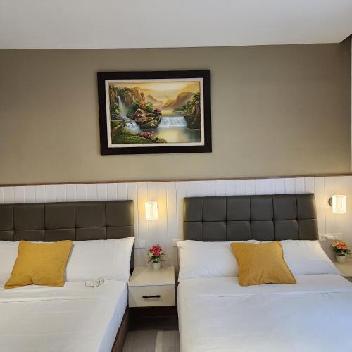 1 dormitorio con 2 camas y una foto en la pared en Twin hearts 328, en Roxas City