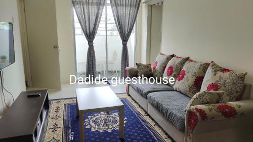 uma sala de estar com um sofá e uma mesa em Dadide guesthouse em Kampong Alor Gajah