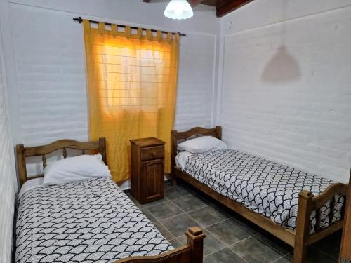 2 camas en una habitación con ventana en Mercedario Aparts en Barreal