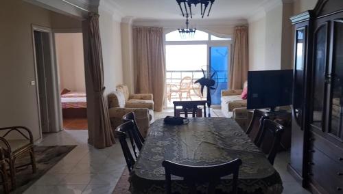 ein Esszimmer mit einem Tisch und ein Wohnzimmer in der Unterkunft برج العزيزية بانوراما بحر للعائلات فقط in Alexandria