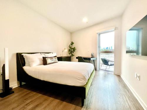 una camera con un grande letto e una grande finestra di NEW One Bedroom Penthouse, Silver Lake + Parking! a Los Angeles