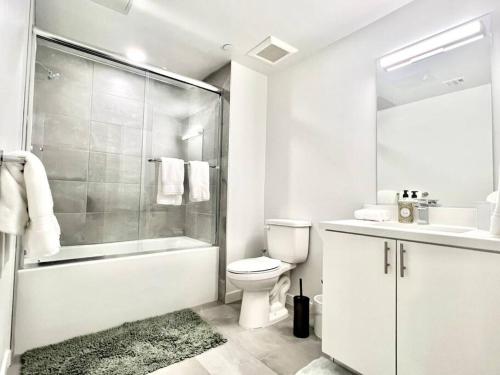 a white bathroom with a toilet and a shower at NEW One Bedroom Penthouse, Silver Lake + Parking! in Los Angeles