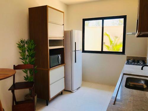 a kitchen with a refrigerator and a window at Casa com piscina exclusiva in Cabo Frio