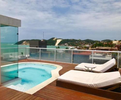 uma varanda com uma piscina no topo de um edifício em Vip Praia Hotel em Natal