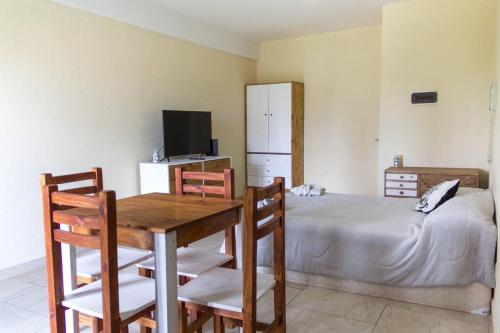 a bedroom with a bed and a table and chairs at Monoambiente céntrico en San Miguel in San Miguel