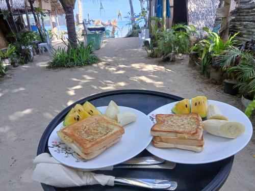 two white plates with sandwiches and fruit on a table at 8 Star Paradise in Locaroc