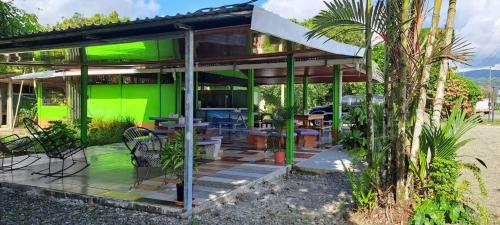 una casa verde con mesa y sillas en Esmeralda en Puerto Jiménez