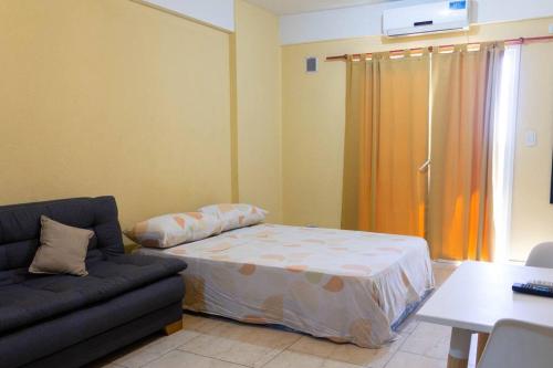 - un salon avec un lit et un canapé dans l'établissement Bello departamento en San Miguel, à General Sarmiento