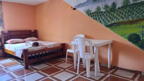 Schlafzimmer mit einem Bett, einem Tisch und Stühlen in der Unterkunft HOTEL CENTRAL TAMESIS in Támesis