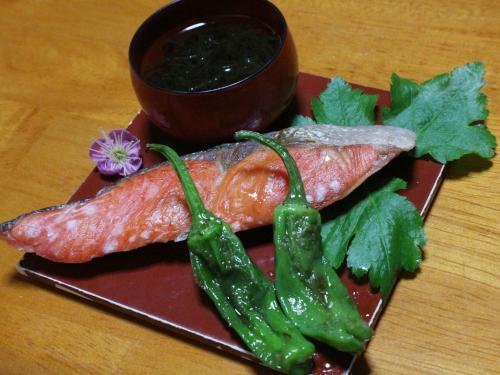 a plate of food with meat and vegetables on a table at Kanko Ryokan Yamato in Ikuma