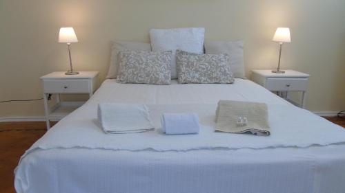 ein weißes Bett mit zwei Kissen und Handtüchern darauf in der Unterkunft Graça River View in Lissabon