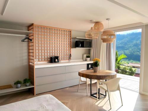 a kitchen with a table and a dining room at Mar de Bougainville in Governador Celso Ramos