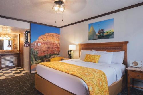 a hotel room with a bed and a painting on the wall at Hotel El Rancho in Gallup