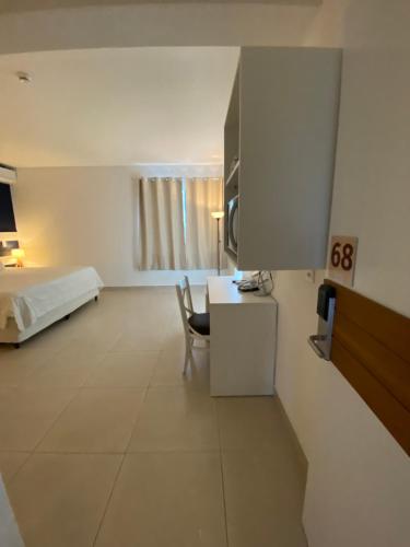 a bedroom with a bed and a desk and a table at Hotel Port Louis in Caraguatatuba