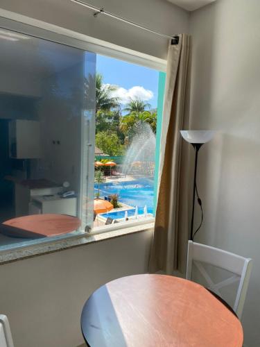 a room with a window with a view of a pool at Hotel Port Louis in Caraguatatuba