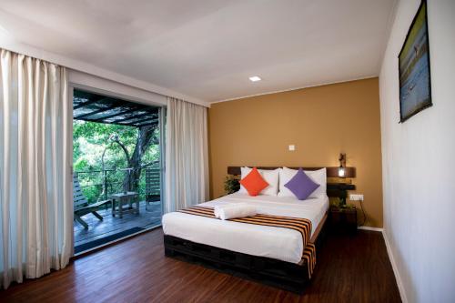 een slaapkamer met een bed en een balkon bij The Backwaters Lodge in Wilpattu
