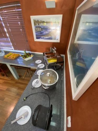 a kitchen with a counter top and a table with food at Hotel Port Louis in Caraguatatuba