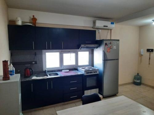eine Küche mit einem Kühlschrank aus Edelstahl und einem Herd in der Unterkunft Hermoso departamento 2 ambientes in General Sarmiento