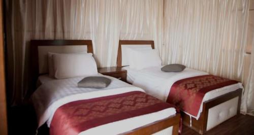 2 bedden in een hotelkamer met acers bij takhyeem al nam in Amman