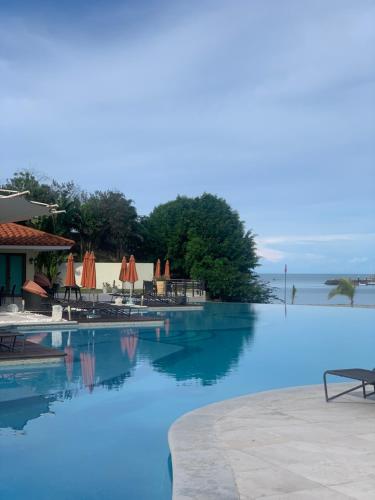 - une piscine avec de l'eau bleue, des tables et des parasols dans l'établissement Vista Mar, à San Carlos